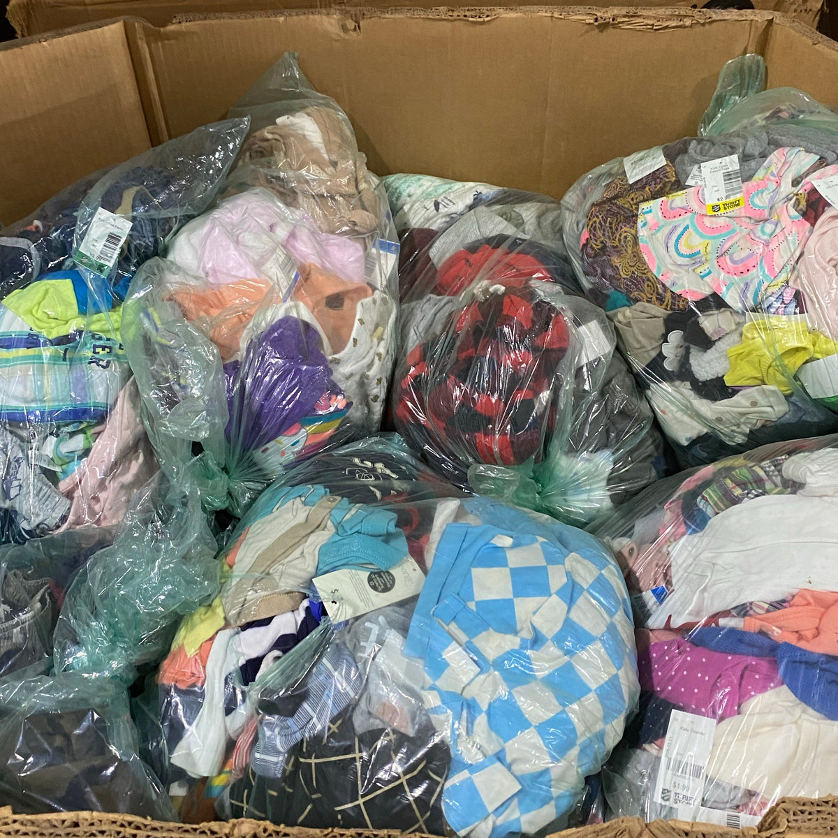 Pallet box filled with assorted used children's clothing.